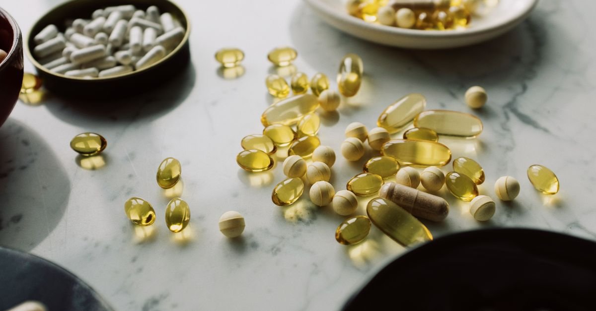 A close-up of assorted pills and supplements arranged on a marble surface, highlighting healthcare and wellness themes.