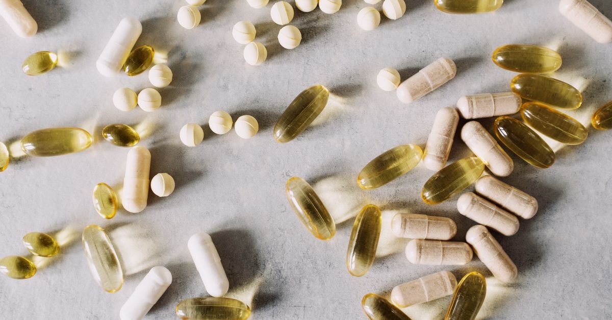 Various vitamins and supplements on a marble background, captured in flat lay style.