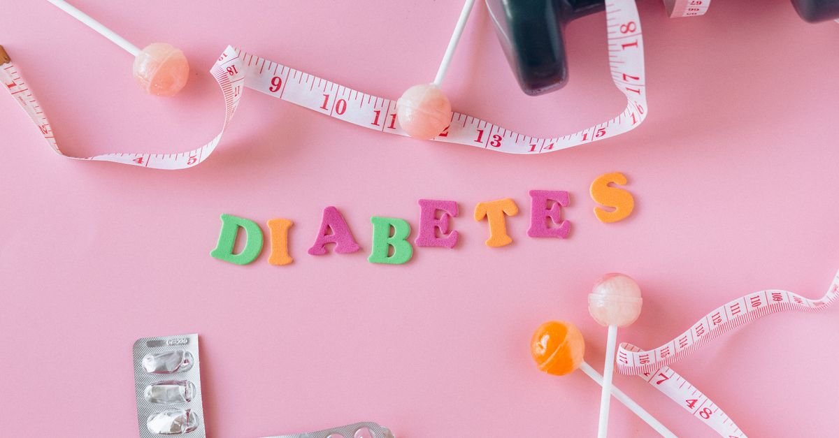 Creative flat lay display of diabetes-related items with a pink backdrop. Ideal for health-related concepts.